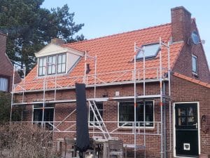 Daklekkage reparatie in uitvoering met steiger